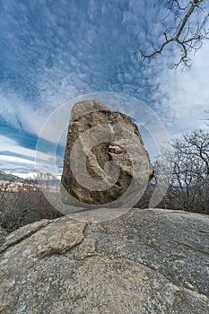 Large boulder of granite rock surounded by trees at Silla de Felipe II Phillip II chair in Guadarrama Mountains photo