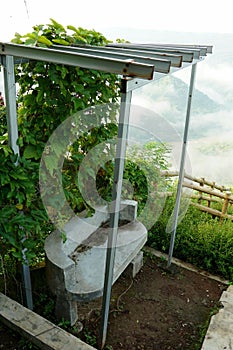 A cement bench positioned atop a hill, designed for relaxing and soaking in panoramic views.