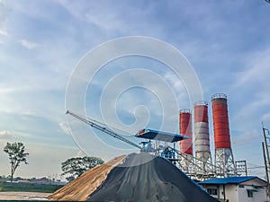 Cement concrete mixing production factory with dramatic sky background. Concrete batching plant at construction site