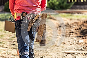 Cement Construction Worker With Toolbelt Holding Various Trowels and Tools On Belt