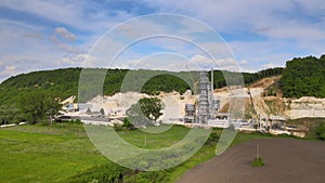 Cement factory at open pit mining of construction sand stone materials with excavators and dump trucks.