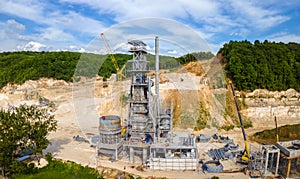 Cement factory at open pit mining of construction sand stone materials with excavators and dump trucks