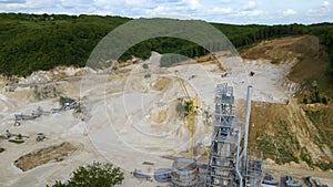 Cement factory at open pit mining of construction sand stone materials with excavators and dump trucks