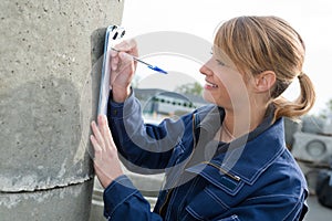 Cement factory saleswoman writing on clipboard