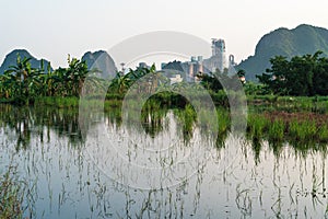 Cement factory settled between karst mountains in idyllic landscape in Ninh Binh, Vietnam