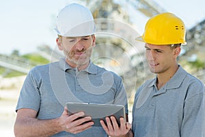 cement factory workers looking at tablet