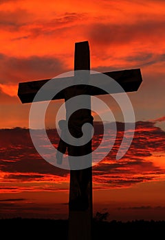 Cement life size cross with body of Jesus as sun sets