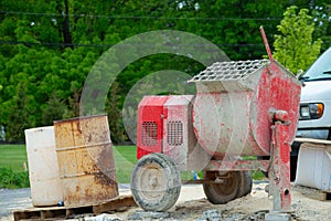 Cement mixer machine at construction site, tools and sand
