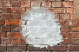 Cement patch over weathered red brick wall