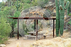 Cement picnic table with metal steel awning in late afternoon shade in natural picnic park outdoor area in sabino park