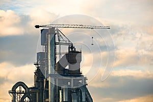 Cement plant with high factory structure and tower crane at industrial production area