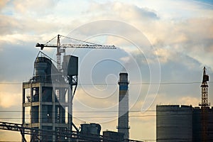 Cement plant with high factory structure and tower crane at industrial production area