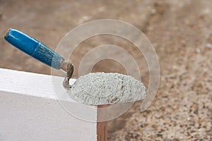Cement powder or mortar with  trowel put on the Lightweight Concrete brick for construction work