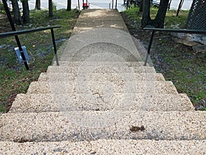 Cement stairs with railing leading to asphalt