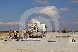 Cement truck pouring cement into a runway construction