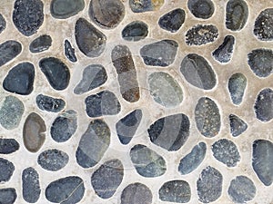 Cement wall background with embedded stones. Texture of pebble stone flooring. Stone decorative wall texture background. Concrete