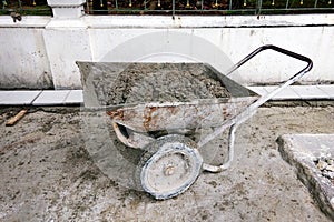 Cement wheelbarrow on sidewalk construction site