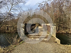 Cemento iron concrete bridge leading over pond to small forest photo