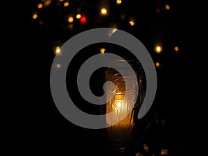 Burning white and colourful candles on a cemetery at night of all the saints, orange lights.