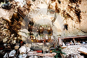 The cemetery with coffins placed in cave and balconies with wooden statues tau tau. Old burial site in Londa, Tanaja, Indonesia