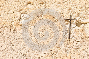 Christian cross on light brown wall background