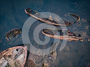 Cemetery of old ships Teriberka Murmansk Russia, wooden remains of industrial fishing boats in sea. Industrialization