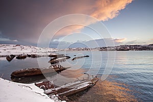 Cemetery of small fishing boats in Teriberke at sunrise. Murmansk region, Russia