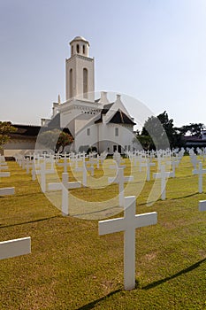 Cemetery with white crosses in front of a church