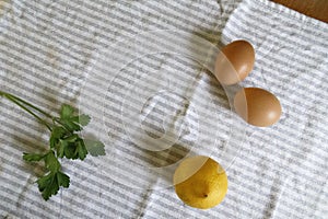 Cenital shot of 2 eggs, parsley and a lemon photo