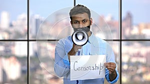 Censored man with taped mouth trying to speak.