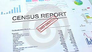Census report confidential, hand stamping seal on official document, statistics photo