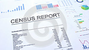 Census report lying on table, graphs charts and diagrams, official document