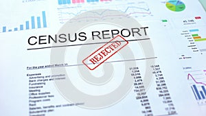 Census report rejected, hand stamping seal on official document, statistics photo