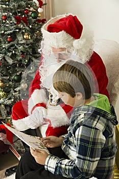 Santa Claus and a boy looking at paper