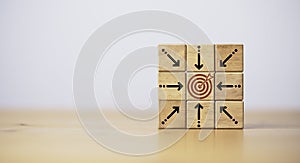 Center dartboard with arrow which print screen on wooden cube for focus on Business achievement goal and objective target concept