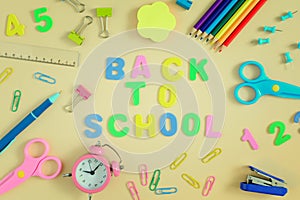 In the center of table the inscription is BACK TO SCHOOL, made in colored letters. Bright colored school and office