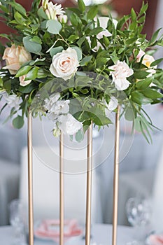 Centerpiece made of fresh flowers stands on the dinner table. Wedding day. Beautiful multicolored bouquet of flowers on a