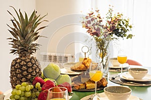 Centerpiece with tray of fresh fruit, bunch of grapes, lots of muffins