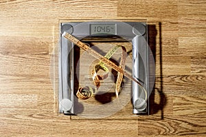The centimeter tape is on the scale showing a lot of kilograms photo
