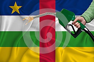 CENTRAL AFRICAN REPUBLIC flag Close-up shot on waving background texture with Fuel pump nozzle in hand. The concept of design
