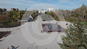 Central alley of the park fly along trees to PC Mariupol Before the war Peaceful city at day.