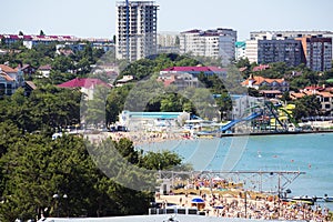 The Central beach of Gelendzhik resort with numerous sunbathers on the sand. Urban landscape.