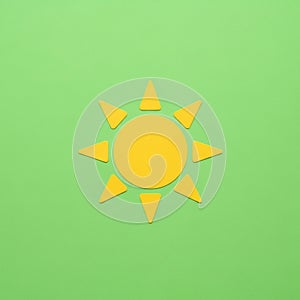 Of a central circle and eight triangular rays on a light green