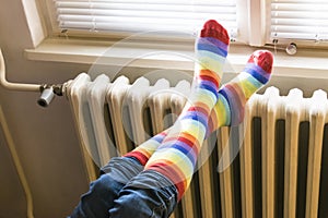 Central heating radiator and woman in striped socks