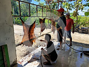 Goat skins are burned over a fire by men during the Eid al-Adha sacrificial ritual