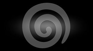 A central light gray gradient on a black background creates a subtle spotlight effect, gradually