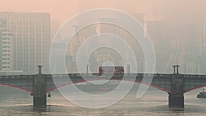 Central London City Skyline with iconic red London bus driving over Lambeth Bridge in atmospheric or
