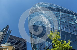 CENTRAL LONDON / ENGLAND - 18.05.2014 - Sky-scraper reflections are seen in the Gherkin's windows.