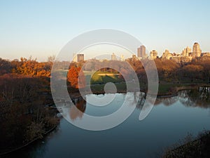 Central Park Pond with Autumn Trees and City Buildings