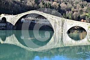 Central part of the Maddalena bridge built in stone, called the devil`s bridge, illuminated by the sun of a cold winter afternoon.